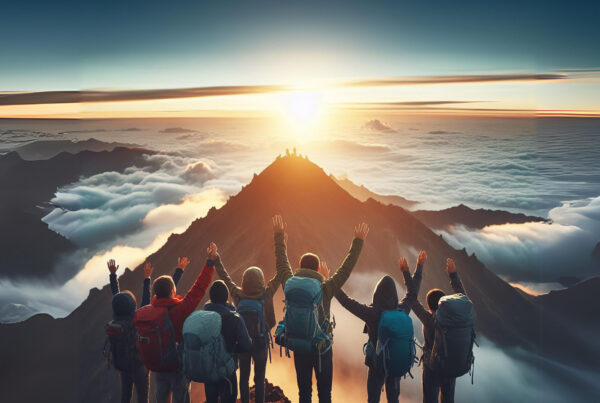People celebrating achieving their goal on top of a mountain